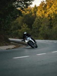 Motorcyclist skillfully navigating a winding road surrounded by autumn foliage.